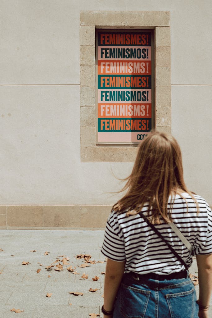 A Woman in a Striped Shirt Looking at a Poster